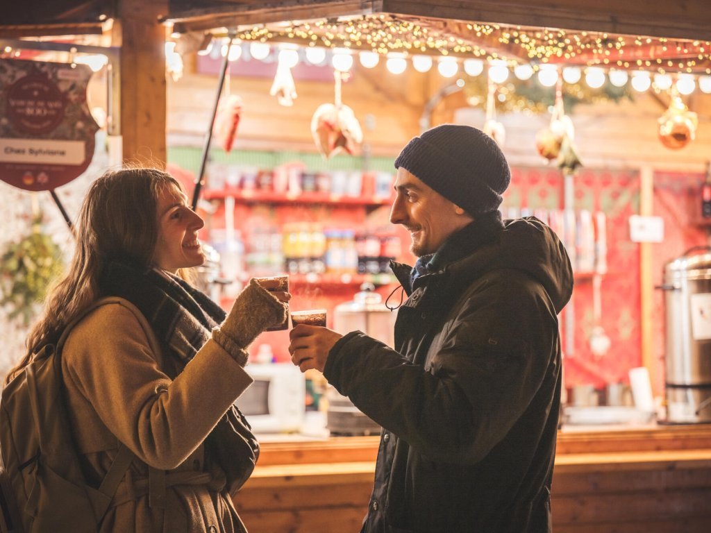 Couple dégustant un vin chaud au marché de noel