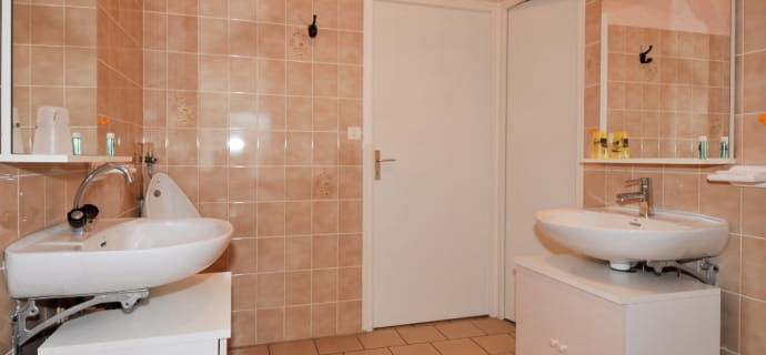 Großes Badezimmer mit zwei Zugängen zu Waschbecken und separatem Duschraum