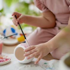 Kind bei der Herstellung von Keramikmalerei