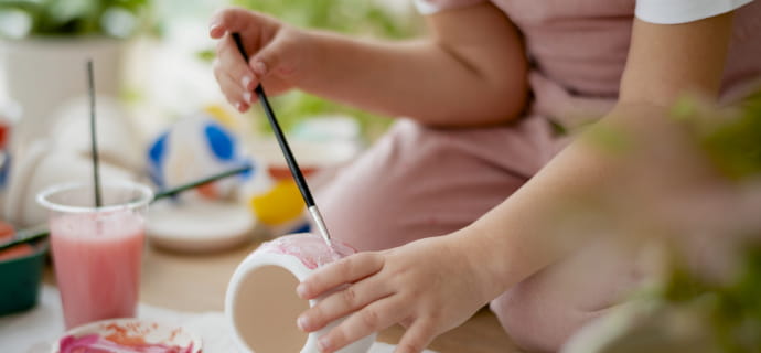 Enfant réalisant de la peinture de céramique